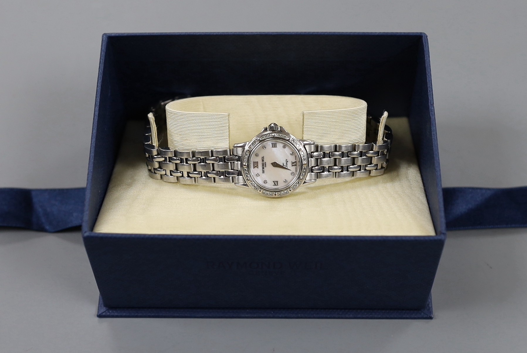 A lady's modern stainless steel Raymond Weil quartz wrist watch and bracelet, with diamond chip set bezel and mother of pearl dial with diamond set markers, with box.